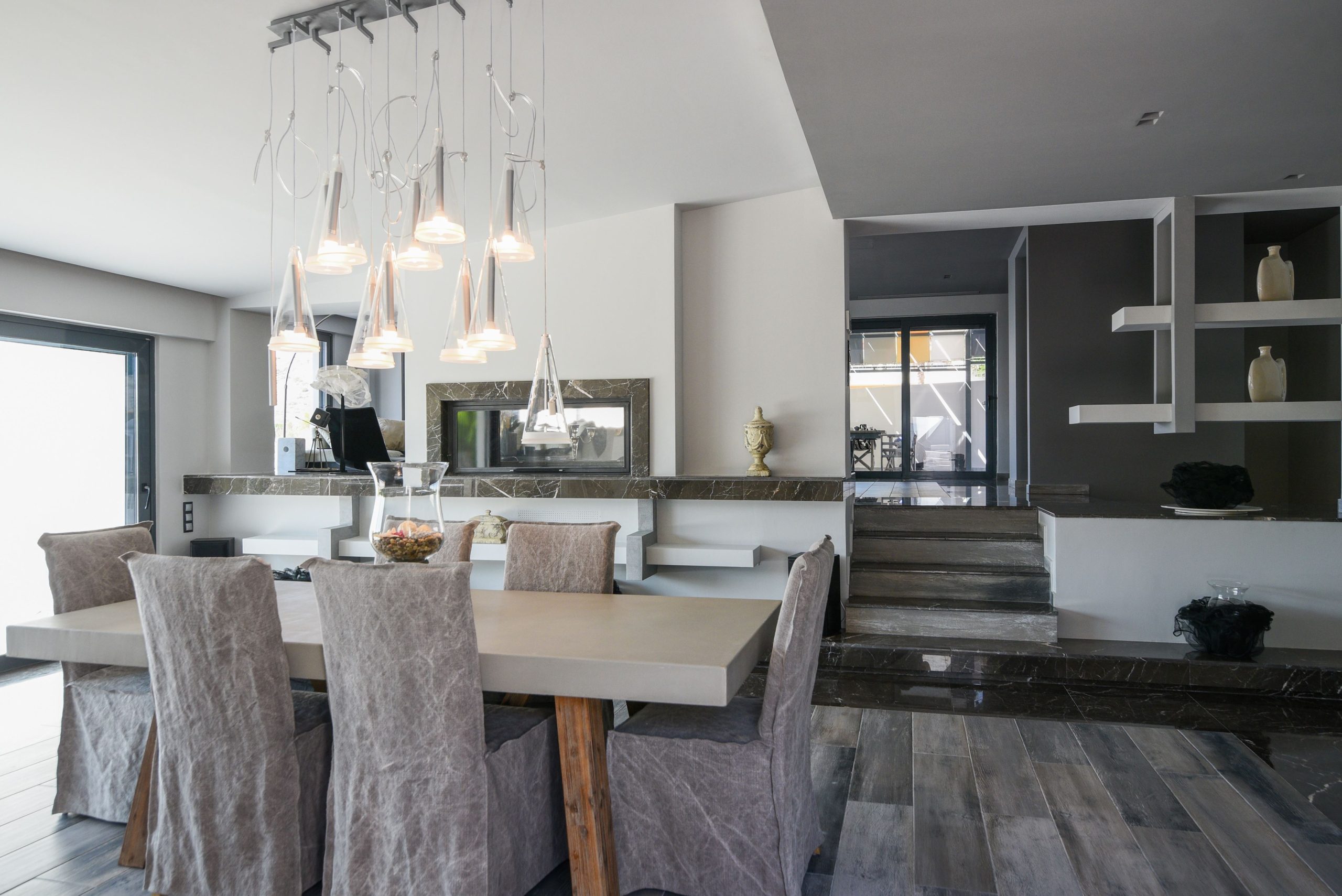 Sounio Beachfront Twin Villas – Dining Area And Kitchen View Open-plan dining area with pendant lights and modern kitchen in the background, Sounio, Athens Riviera, Greece