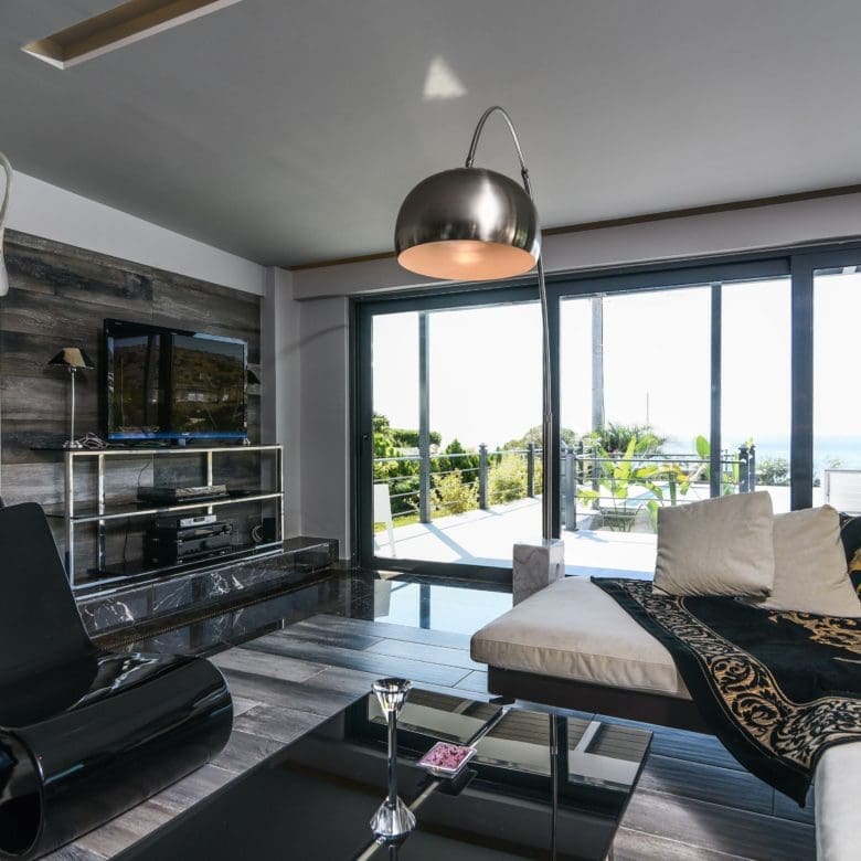 Open-plan living room with seating area and large sliding doors to the balcony, Sounio, Athens Riviera, Greece