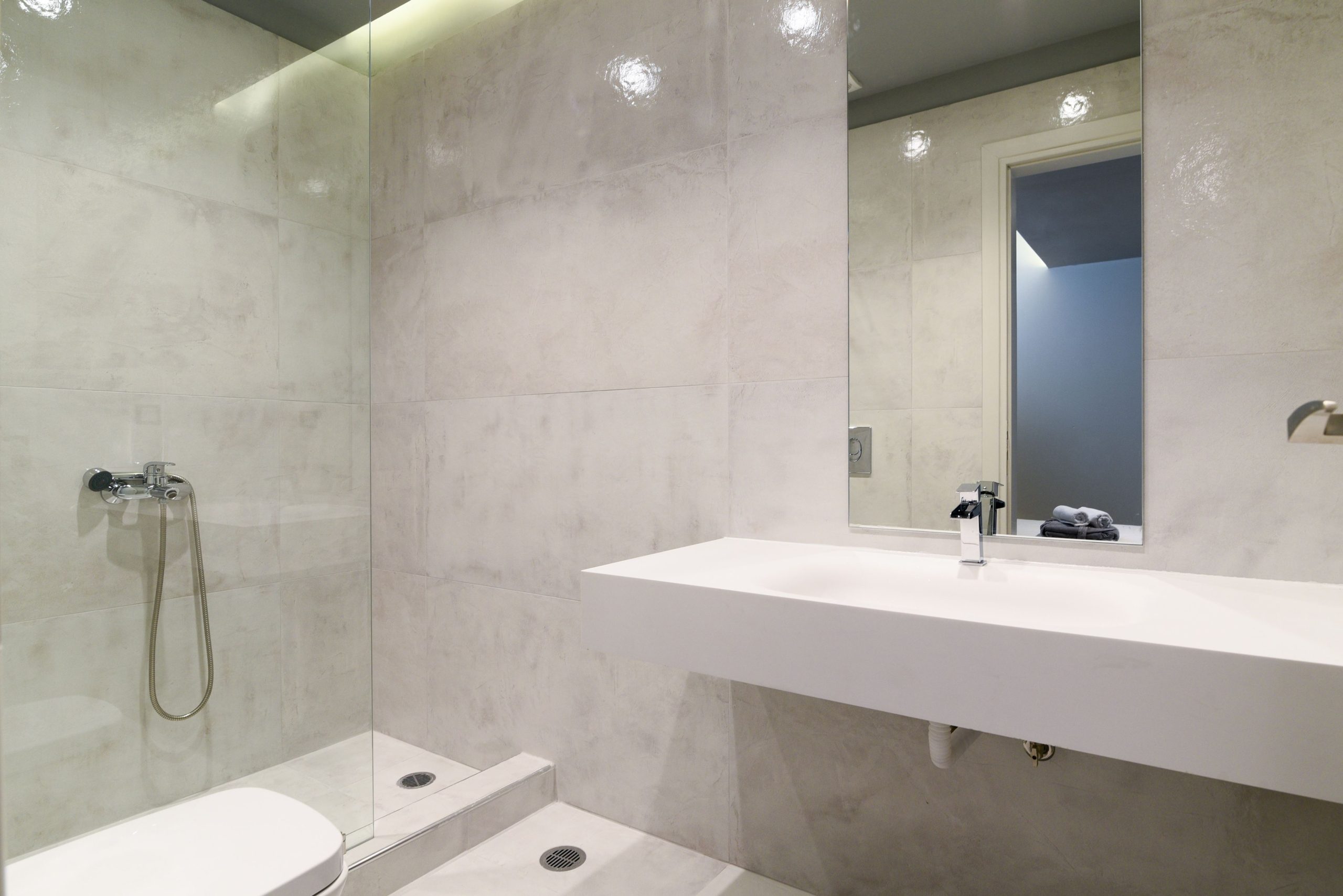 Sounio Beachfront Twin Villas – Minimal Bathroom With Shower Minimal bathroom with walk-in shower, white vanity, and clean stone-look finishes, Sounio, Athens Riviera, Greece