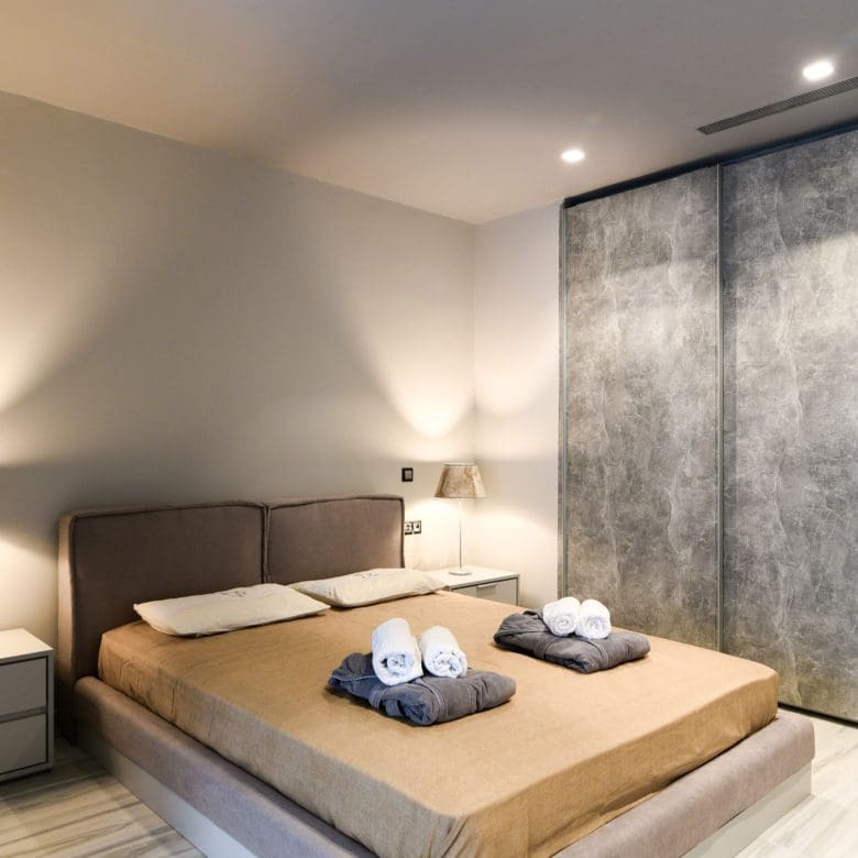 Bedroom with double bed, textured wall, and warm bedside lighting, Sounio, Athens Riviera, Greece