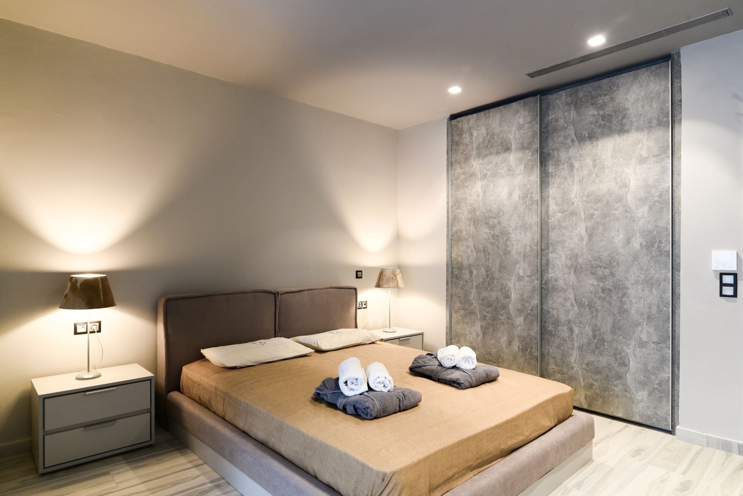 Sounio Beachfront Twin Villas – Bedroom With Textured Wall Bedroom with double bed, textured wall, and warm bedside lighting, Sounio, Athens Riviera, Greece