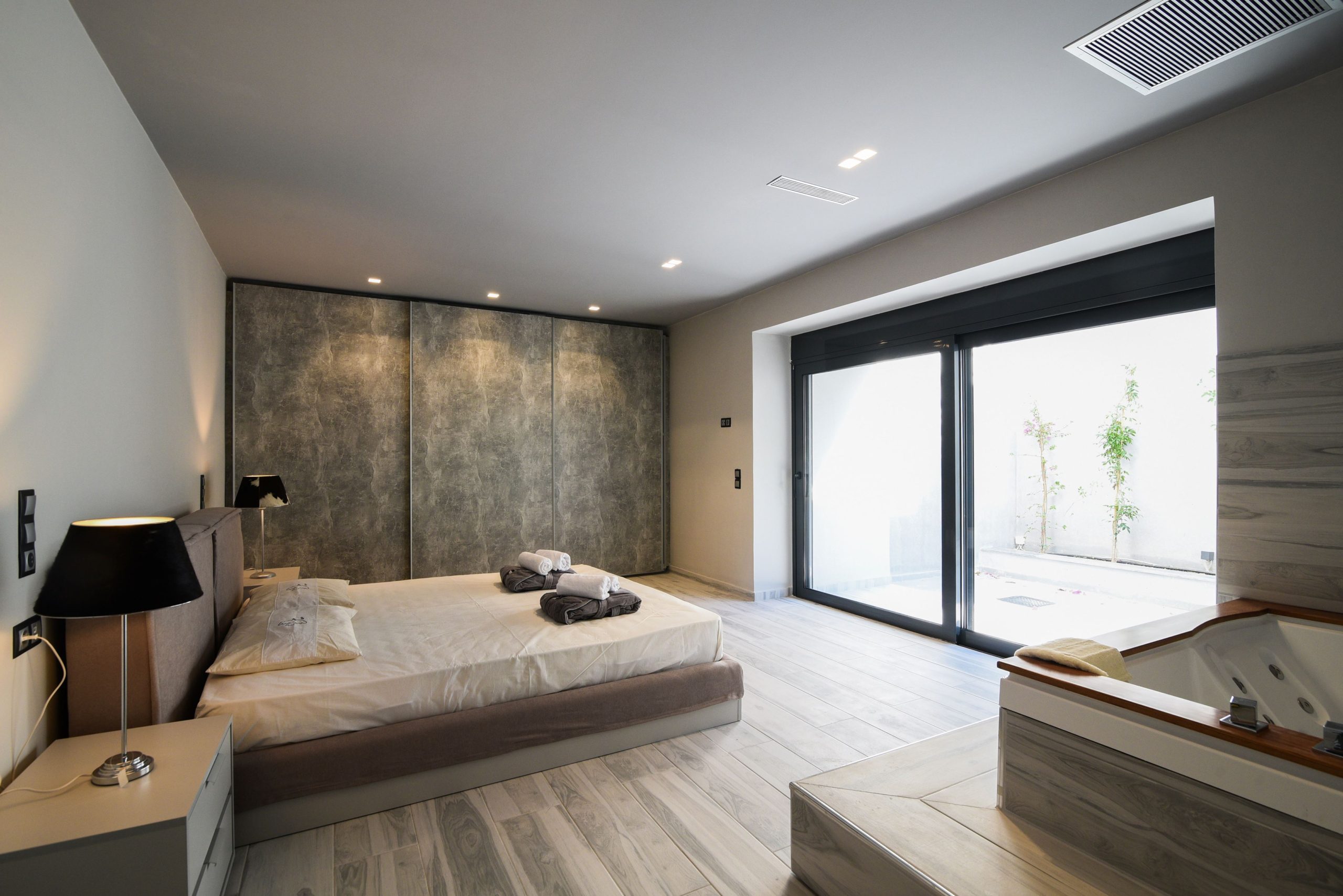 Sounio Beachfront Twin Villas – Bedroom With Balcony Doors Modern bedroom with double bed and large sliding doors to the balcony, Sounio, Athens Riviera, Greece