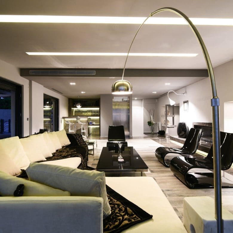 Open-plan living room with modern seating and feature ceiling lighting, Sounio, Athens Riviera, Greece
