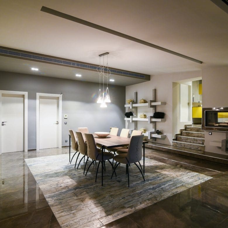 Open-plan dining and kitchen area with modern lighting and bar seating, Sounio, Athens Riviera, Greece