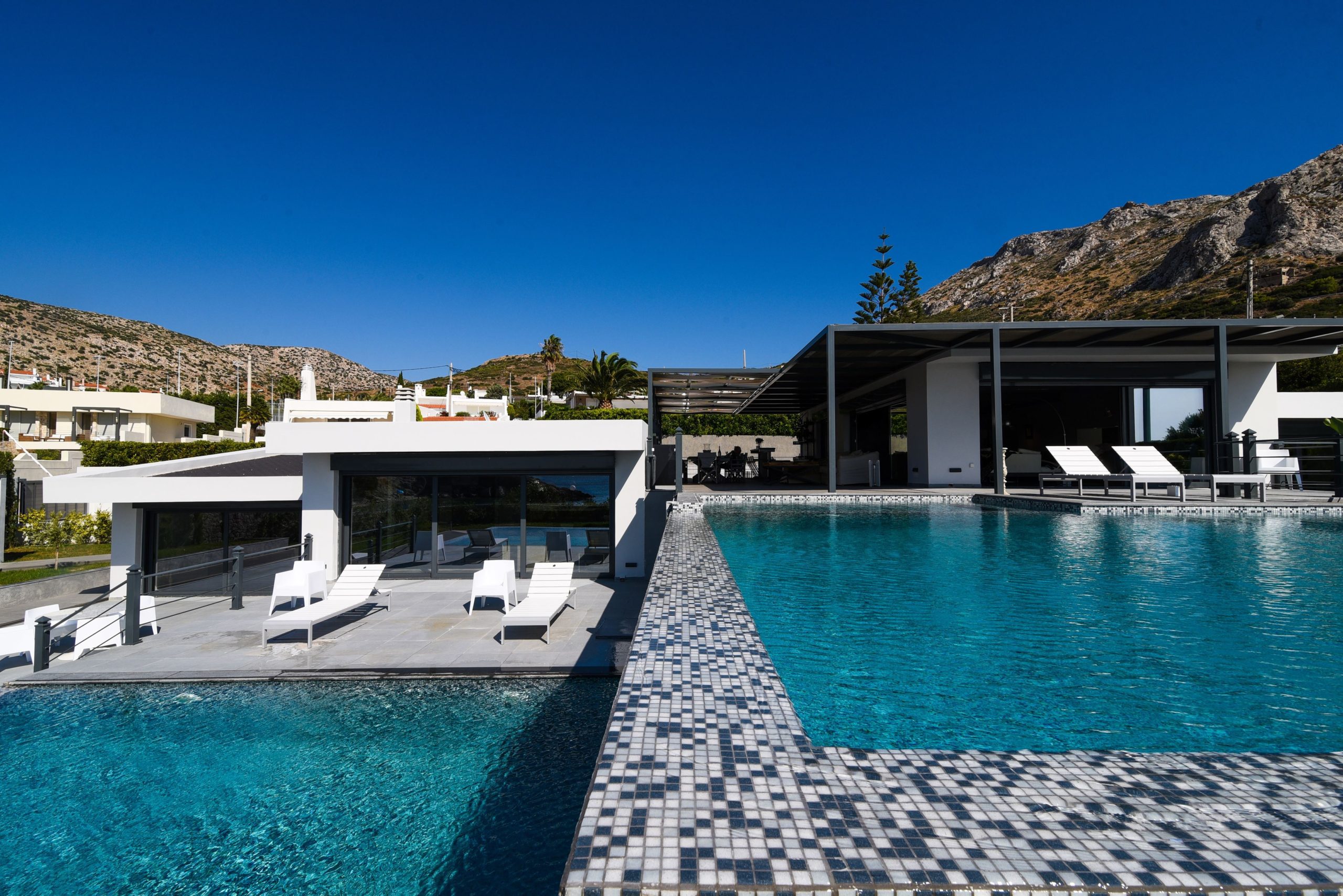 Sounio Beachfront Twin Villas – Pool View With Sun Loungers Infinity pool view with sun loungers and modern villa volumes, Sounio, Athens Riviera, Greece