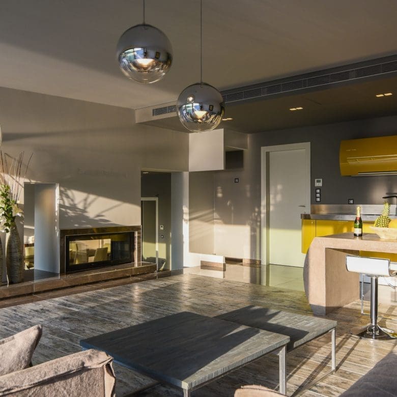Open-plan living room and kitchen with island, pendant lights, and evening ambiance, Sounio, Athens Riviera, Greece