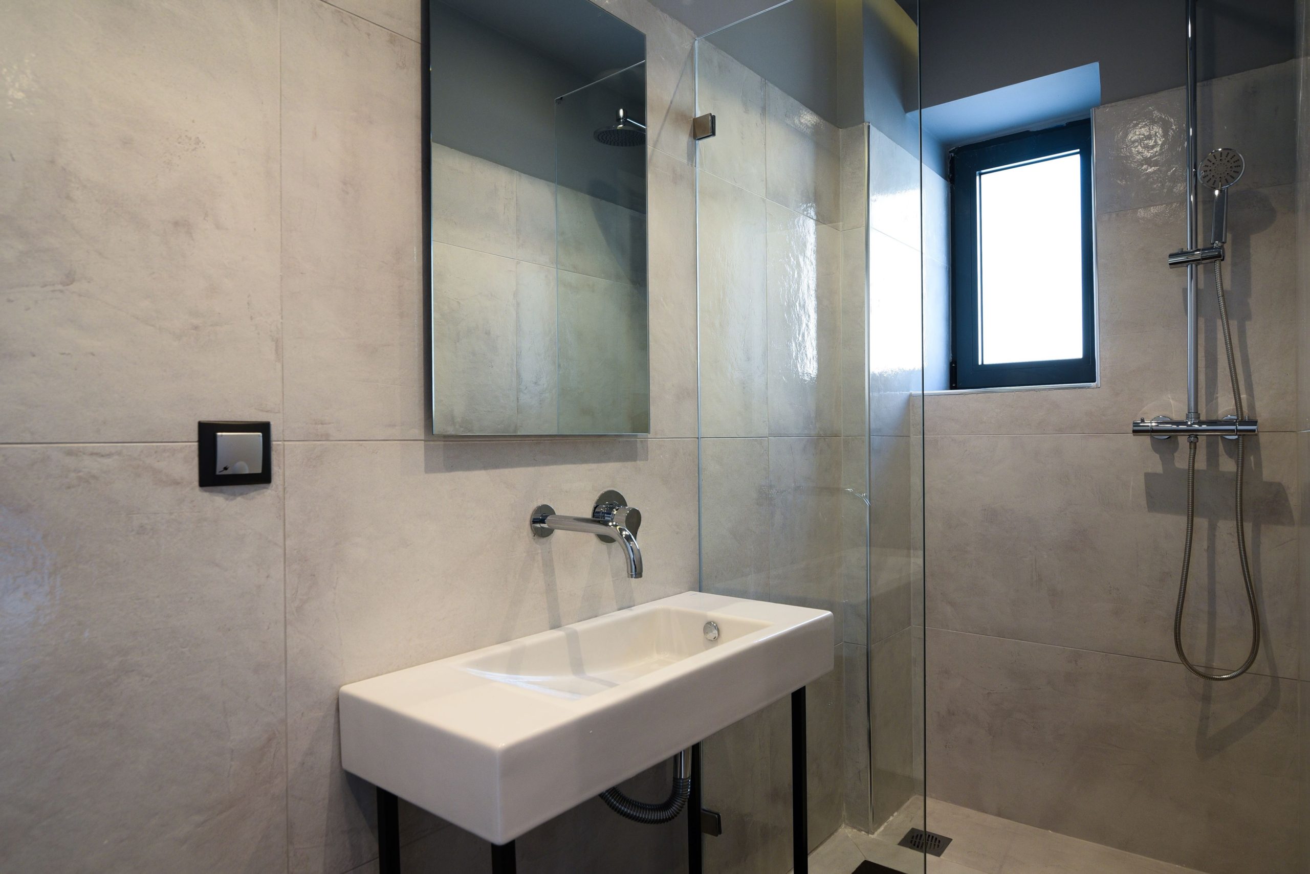 Sounio Beachfront Twin Villas – Minimal Bathroom With Shower Minimal bathroom with wall-mounted sink, walk-in shower, and window, Sounio, Athens Riviera, Greece