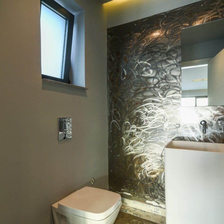 Compact bathroom with toilet, vanity, and textured stone feature wall, Sounio, Athens Riviera, Greece