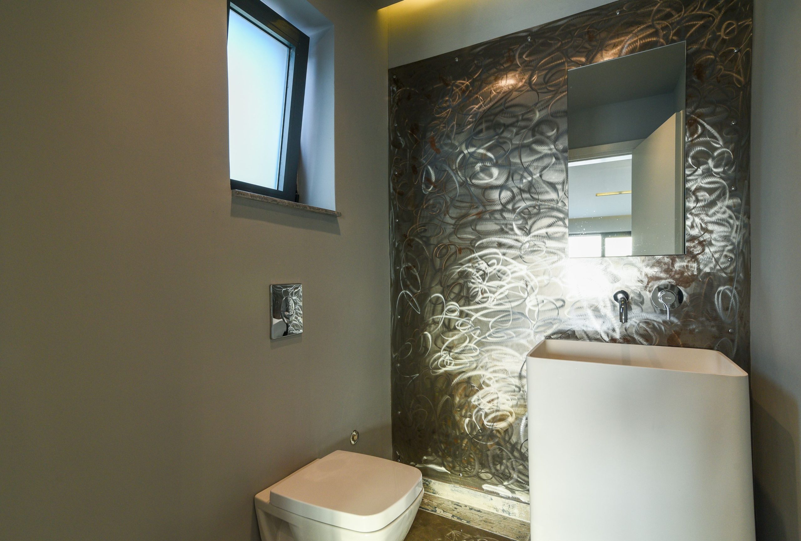 Sounio Beachfront Twin Villas – Bathroom With Stone Feature Wall Compact bathroom with toilet, vanity, and textured stone feature wall, Sounio, Athens Riviera, Greece
