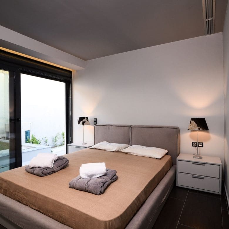 Modern bedroom with double bed and large sliding doors to the terrace, Sounio, Athens Riviera, Greece