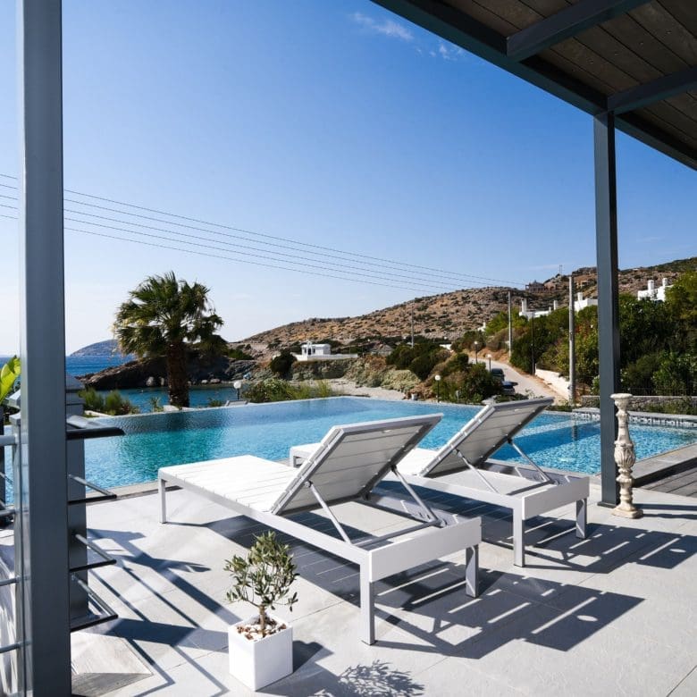 Poolside terrace with sun loungers under a pergola and sea-view setting, Sounio, Athens Riviera, Greece