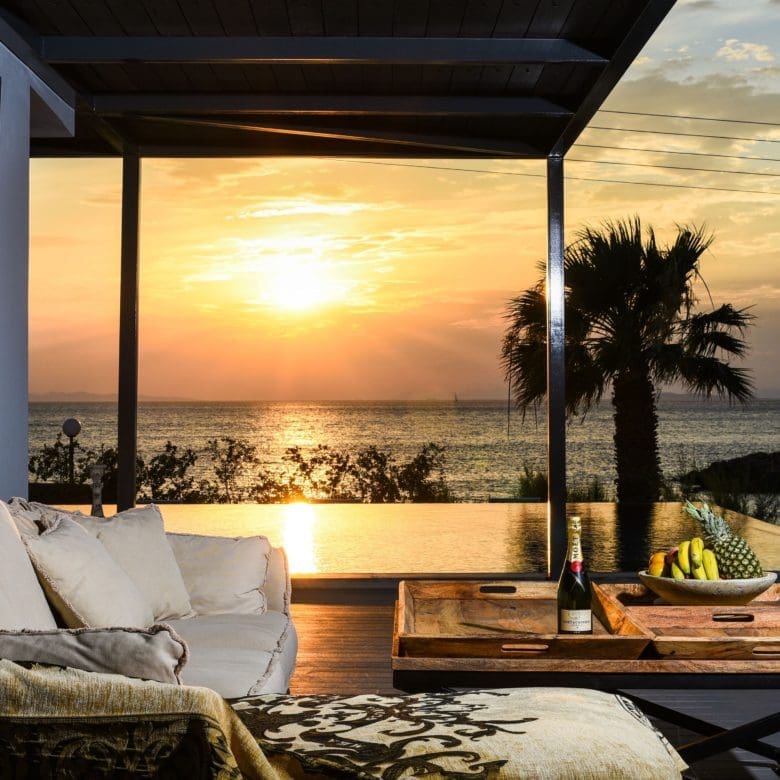 Covered outdoor lounge at sunset with seating and warm ambient lighting, Sounio, Athens Riviera, Greece