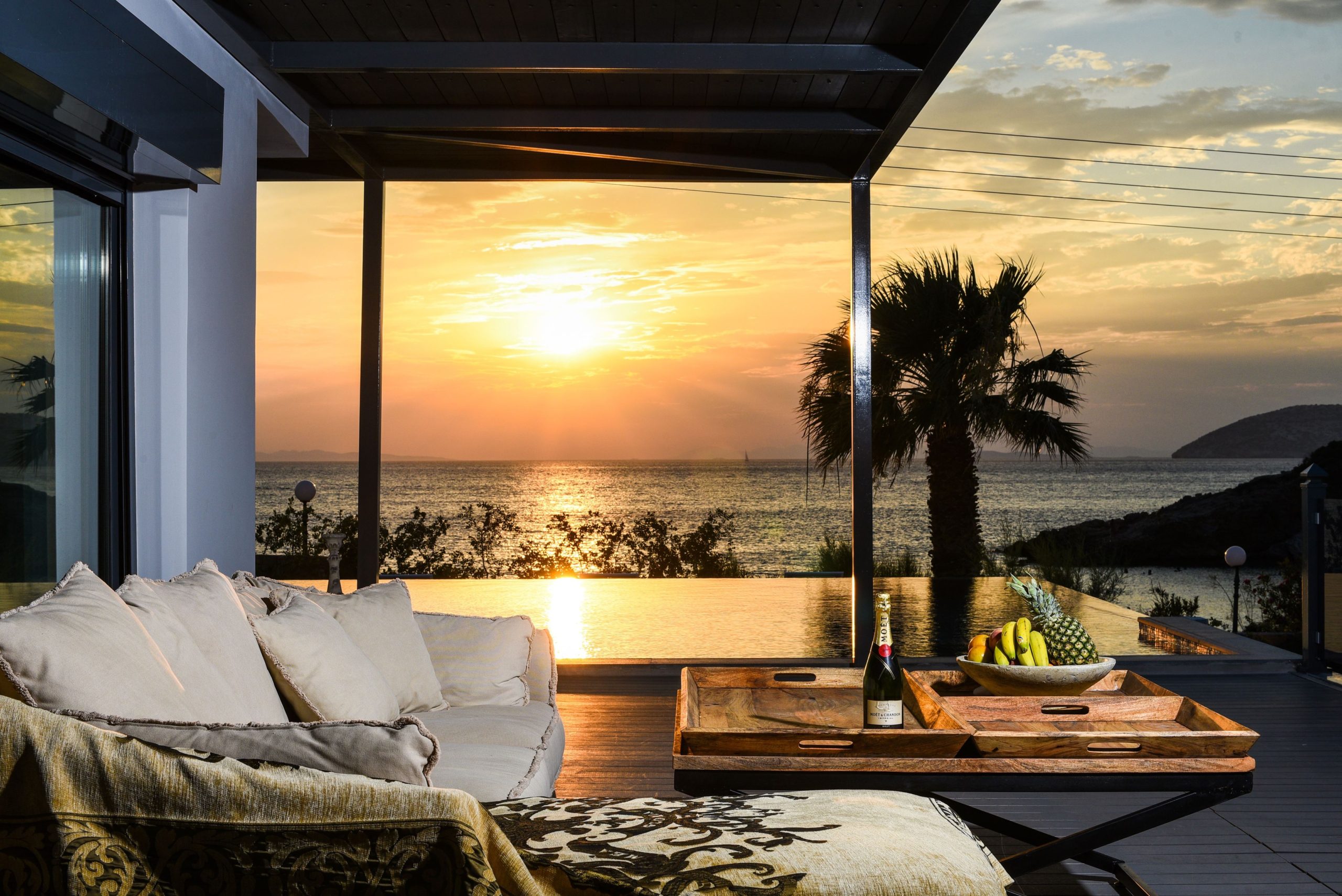 Sounio Beachfront Twin Villas – Sunset Outdoor Lounge Covered outdoor lounge at sunset with seating and warm ambient lighting, Sounio, Athens Riviera, Greece