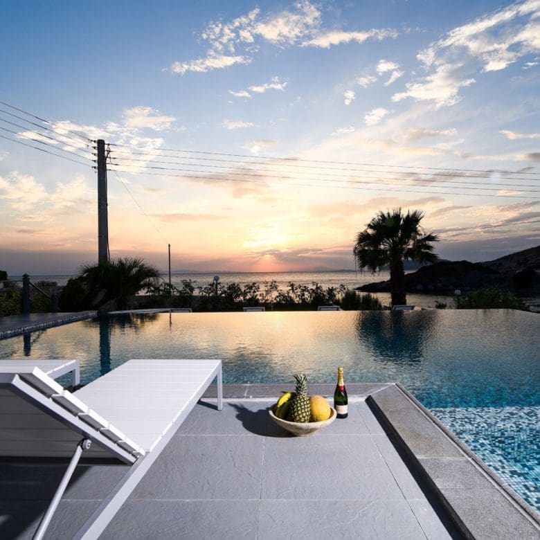 Infinity pool at sunset with loungers and open horizon views, Sounio, Athens Riviera, Greece
