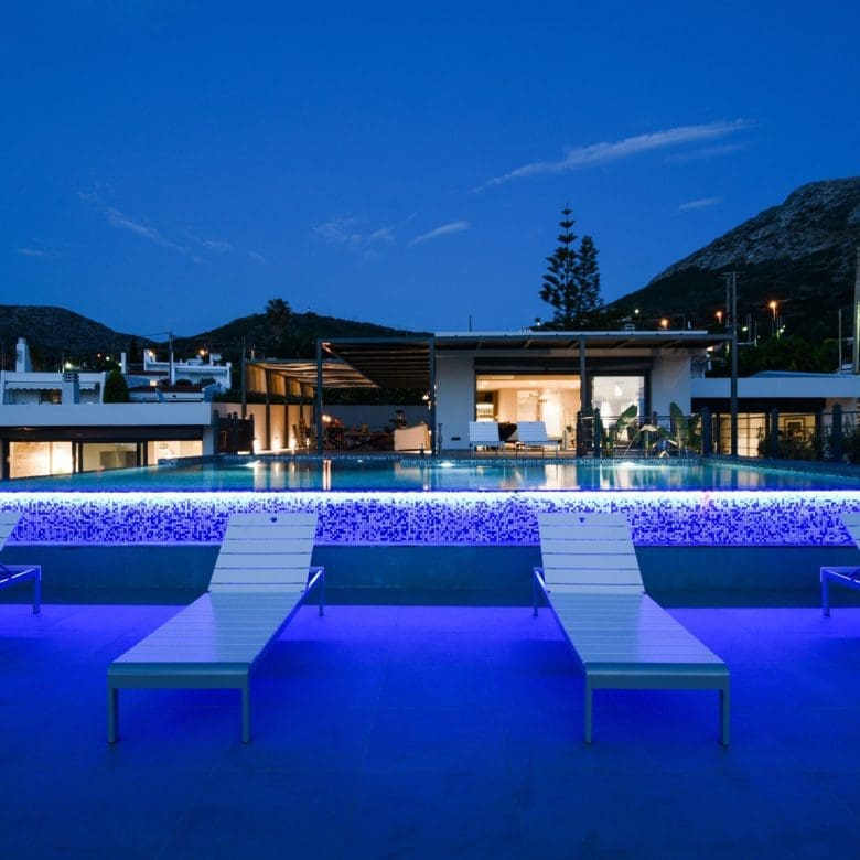 Night view of the modern villa with illuminated swimming pool and outdoor seating, Sounio, Athens Riviera, Greece