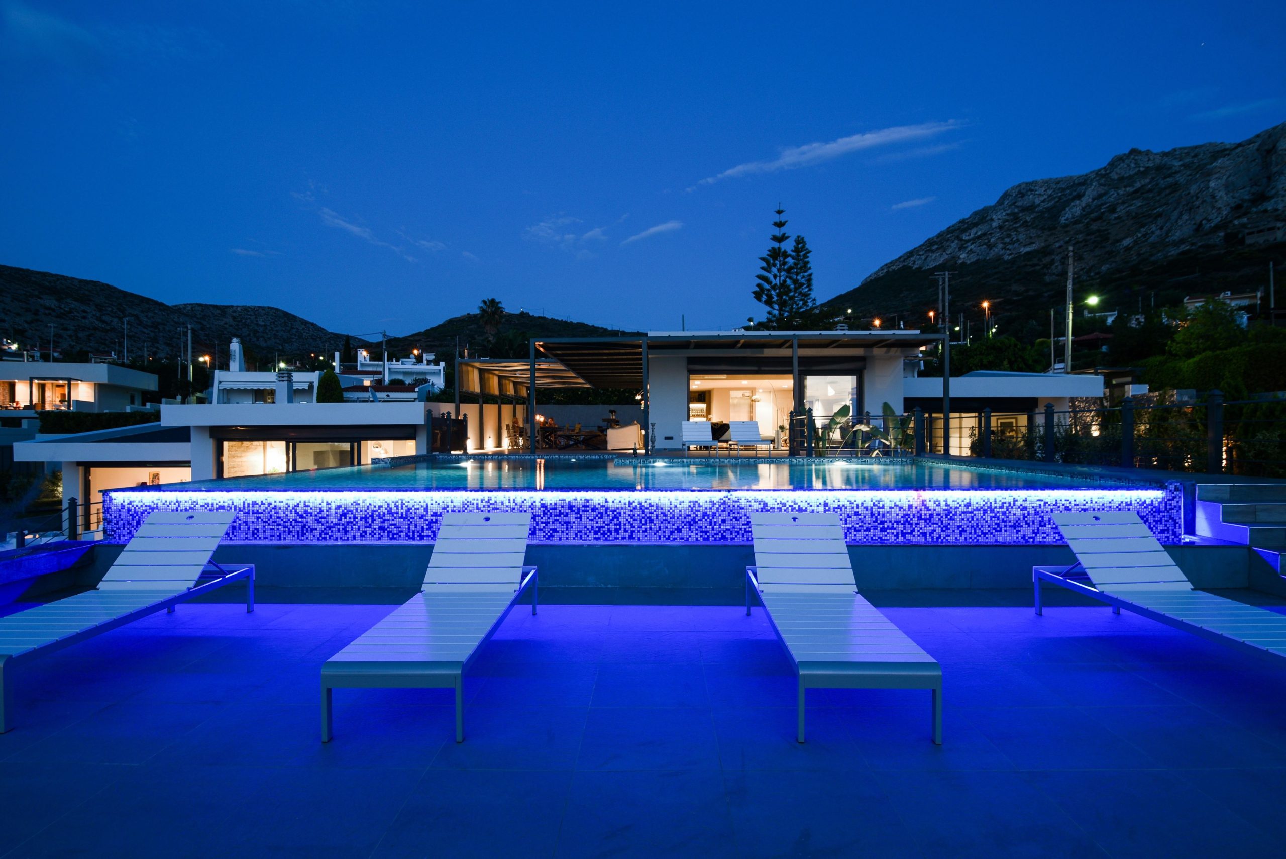 Sounio Beachfront Twin Villas – Night View With Lit Pool Night view of the modern villa with illuminated swimming pool and outdoor seating, Sounio, Athens Riviera, Greece