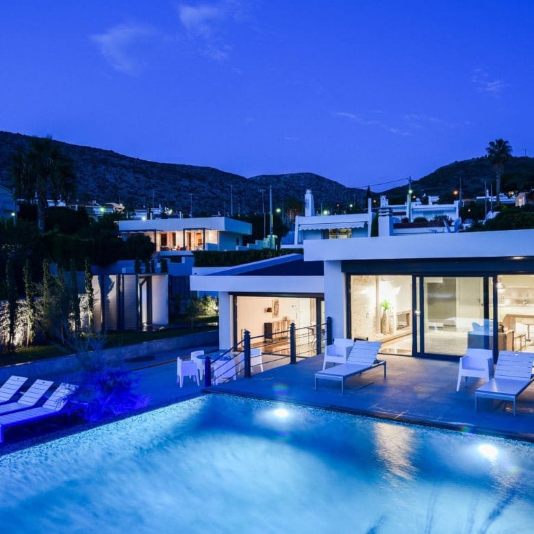 Night view of the villa with illuminated pool and outdoor lounge areas, Sounio, Athens Riviera, Greece
