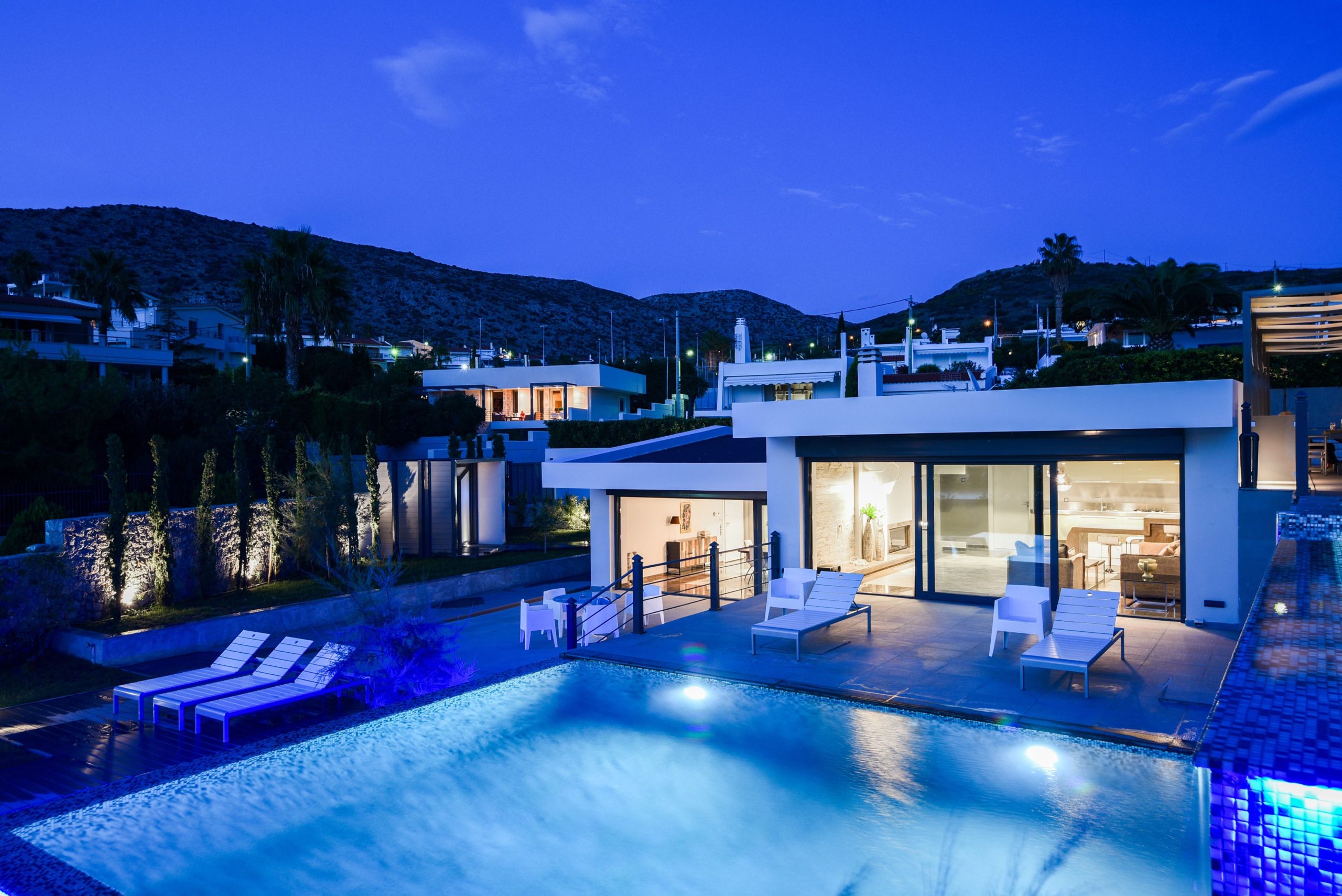 Sounio Beachfront Twin Villas – Night Exterior With Lit Pool Night view of the villa with illuminated pool and outdoor lounge areas, Sounio, Athens Riviera, Greece