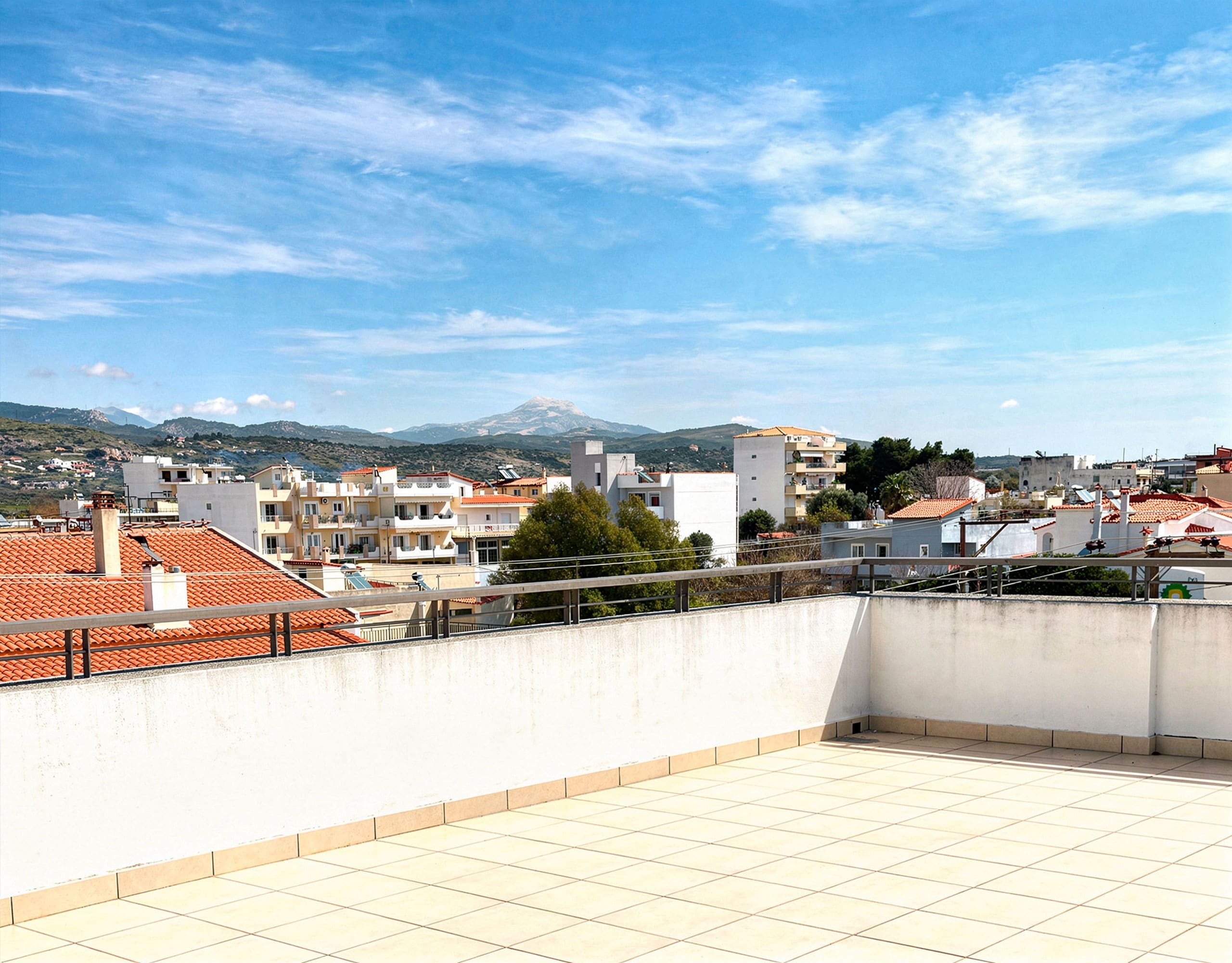 Large terrace with tiled floor and open views over rooftops, Vasiliko, Evia, Greece