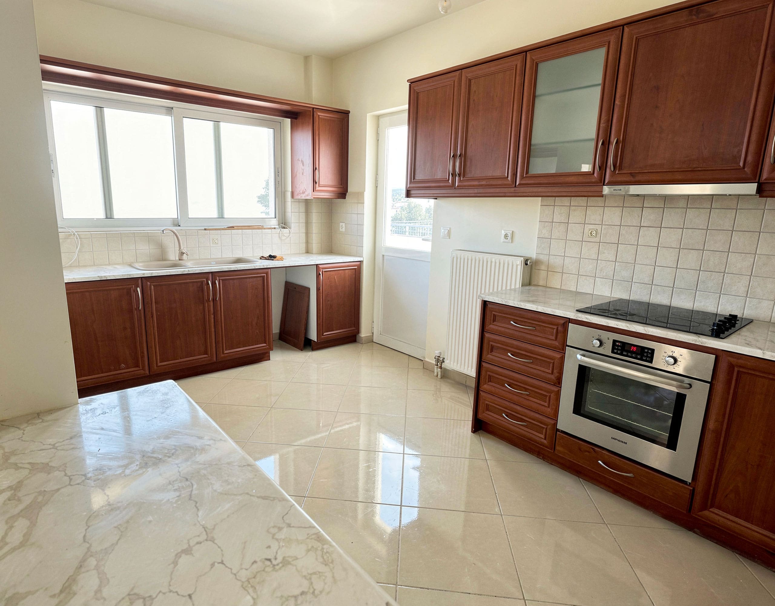 Kitchen with wooden cabinets, built-in oven, and tiled floor, Vasiliko, Evia, Greece