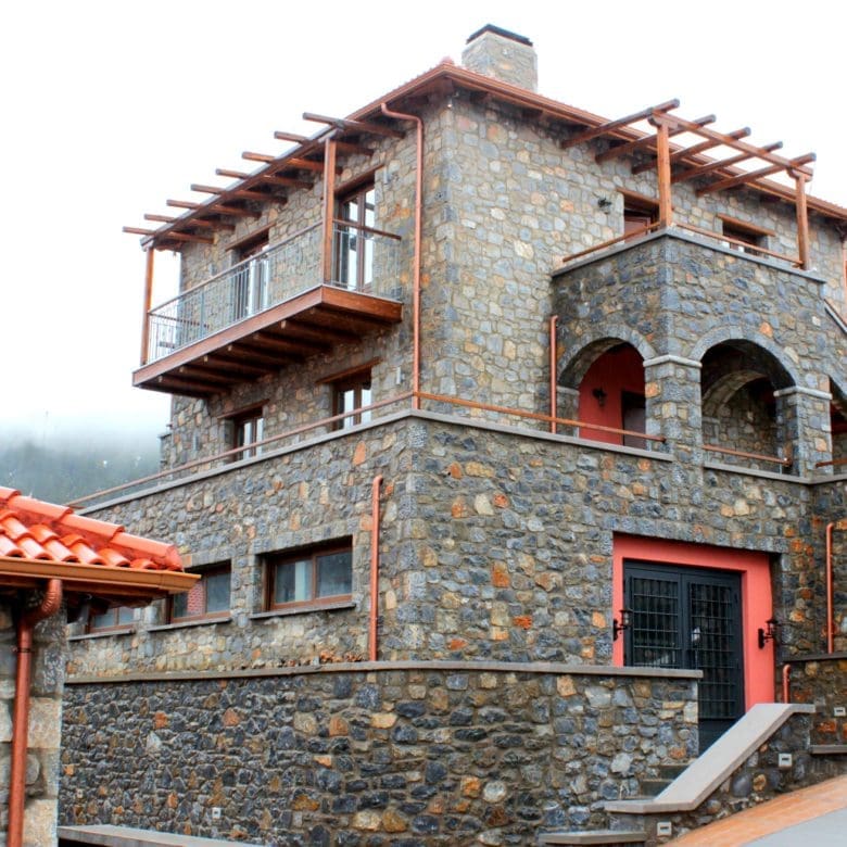 Stone-built hotel exterior with balconies and red-tiled roofs, Kardaras, Mount Mainalo, Arcadia, Greece