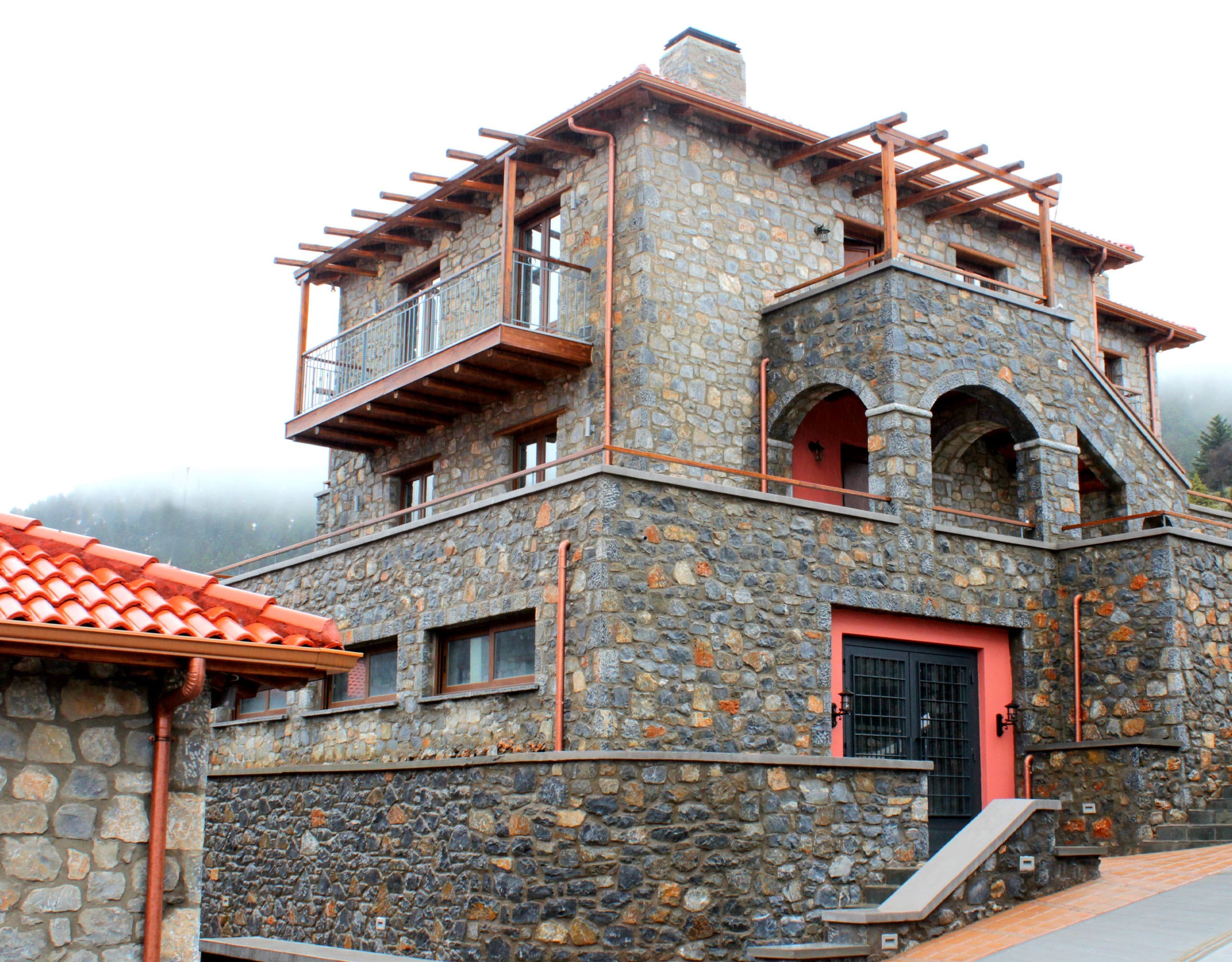 Stone-built hotel exterior with balconies and red-tiled roofs, Kardaras, Mount Mainalo, Arcadia, Greece