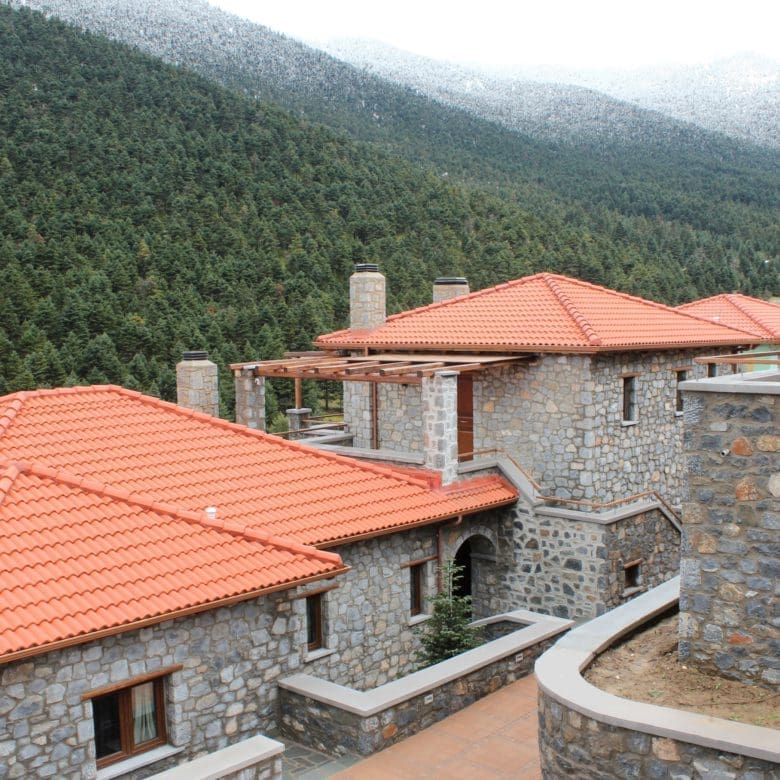 Panoramic view over stone rooftops and green mountain slopes, Kardaras, Mount Mainalo, Arcadia, Greece
