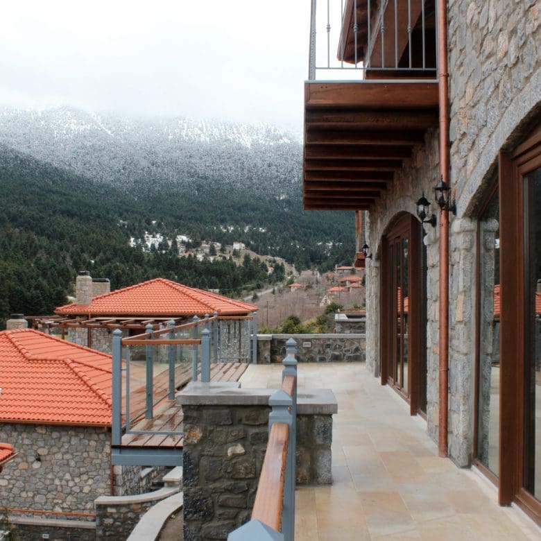 Balcony walkway with stone facade and views over red-tiled rooftops, Kardaras, Mount Mainalo, Arcadia, Greece