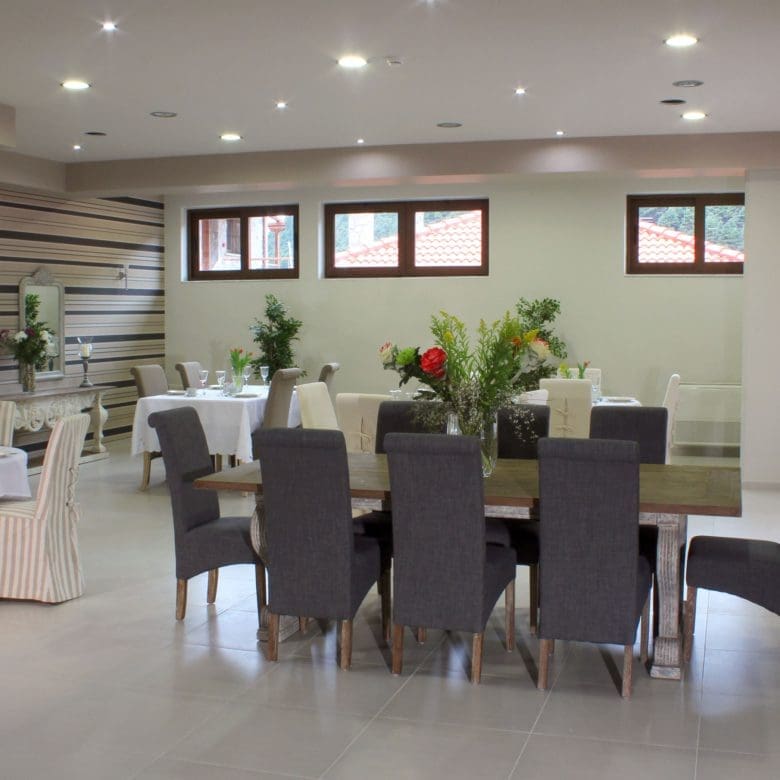 Dining room with long table, chairs, and bright interior lighting, Kardaras, Mount Mainalo, Arcadia, Greece