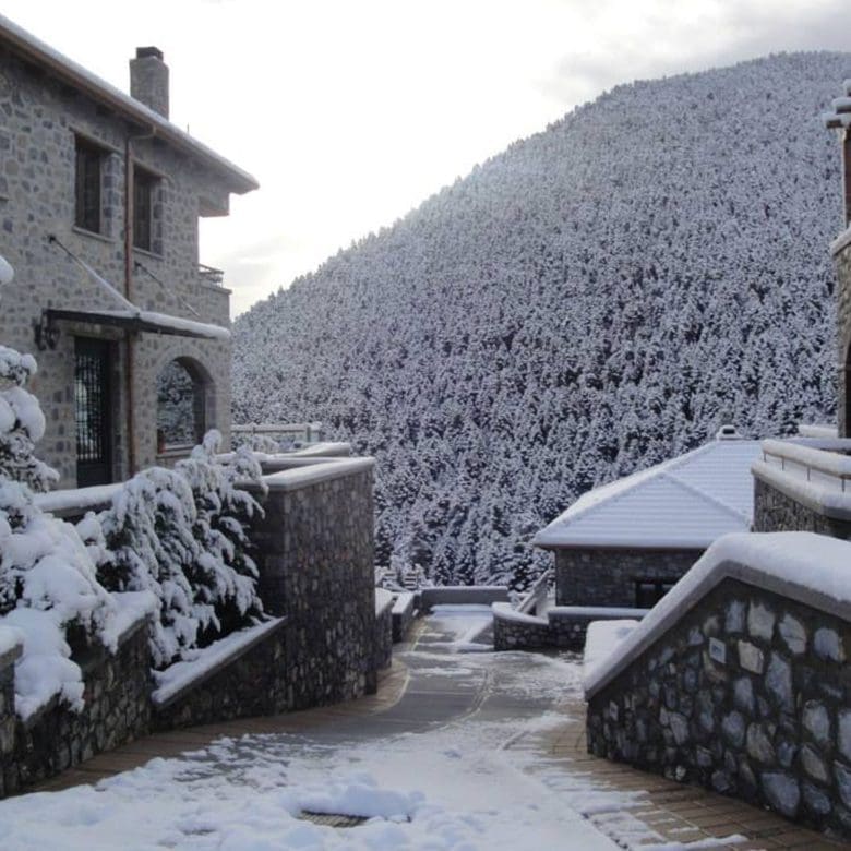 Winter view of the stone-built hotel with snow-covered surroundings, Kardaras, Mount Mainalo, Arcadia, Greece