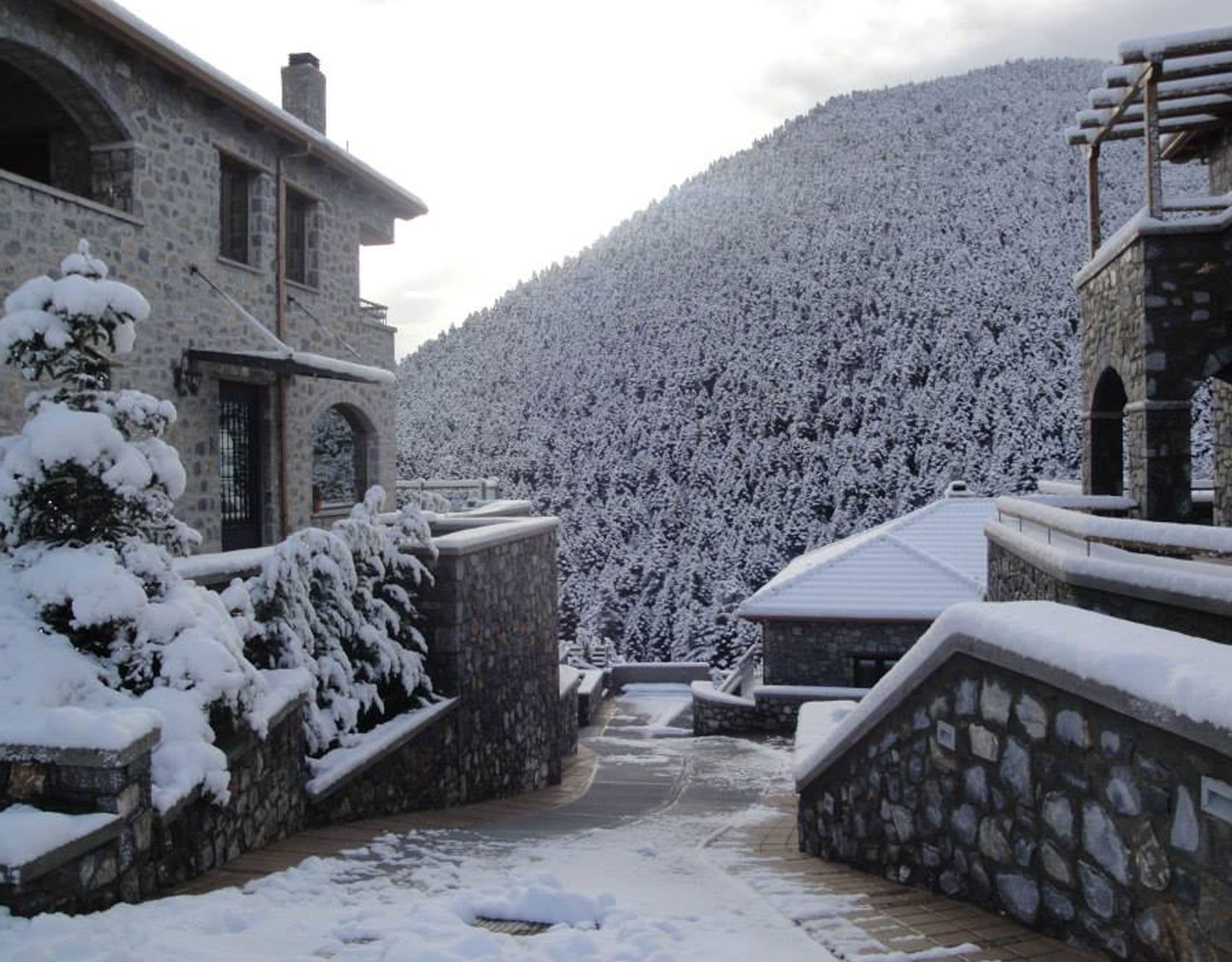 Winter view of the stone-built hotel with snow-covered surroundings, Kardaras, Mount Mainalo, Arcadia, Greece