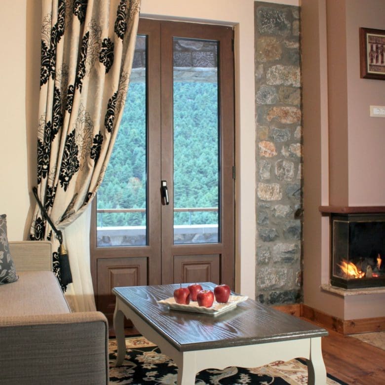 Hotel lounge with classic seating, coffee table, and stone wall detail, Kardaras, Mount Mainalo, Arcadia, Greece