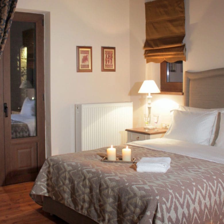Guest bedroom detail with double bed, bedside lamp, and warm decor, Kardaras, Mount Mainalo, Arcadia, Greece