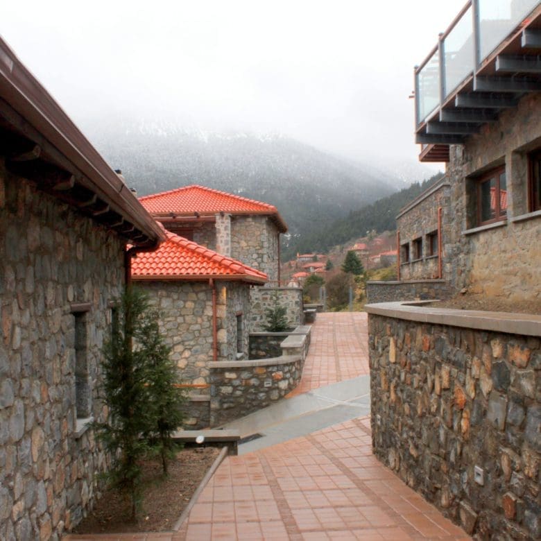 Outdoor walkway between stone buildings with red-tiled roofs, Kardaras, Mount Mainalo, Arcadia, Greece