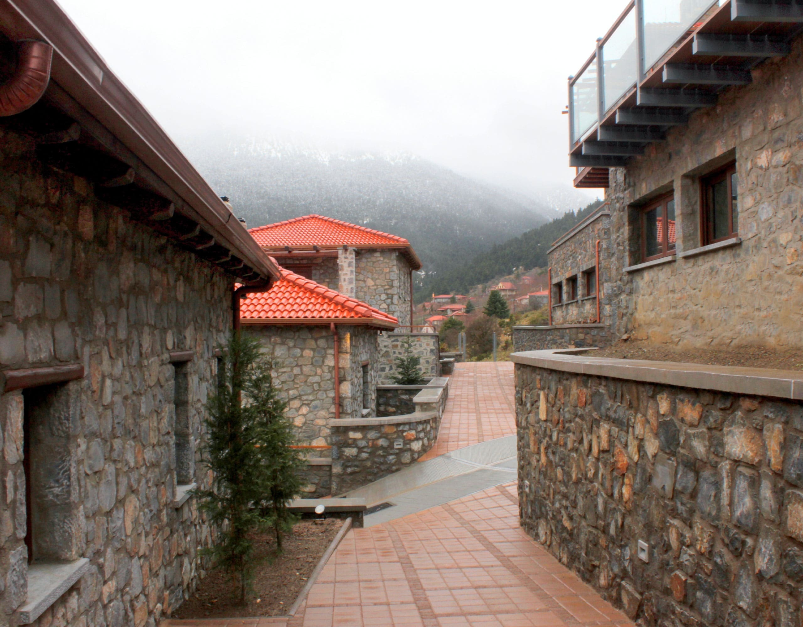 Outdoor walkway between stone buildings with red-tiled roofs, Kardaras, Mount Mainalo, Arcadia, Greece