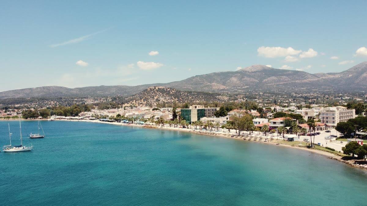 Aerial Coastal View With Mountains Aerial coastal view with turquoise sea, shoreline promenade, and mountains in the background
