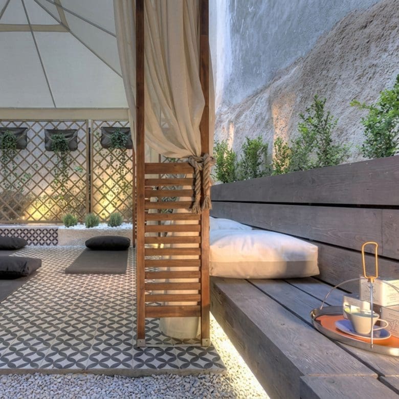 Outdoor courtyard lounge with daybeds, privacy screens, and soft evening lighting, Pasalimani (Zea Marina), Piraeus, Greece