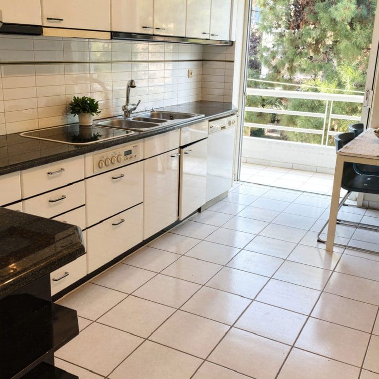 Kitchen with white cabinetry, black countertops, and tiled floor, Voula, Athens Riviera, Greece