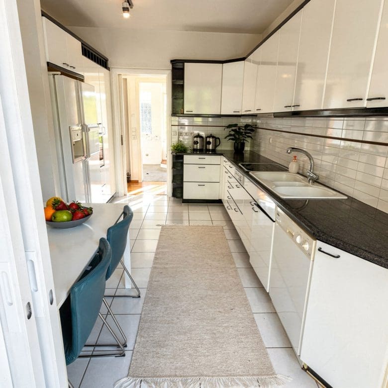Galley kitchen with white cabinets, black countertops, and long corridor layout, Voula, Athens Riviera, Greece
