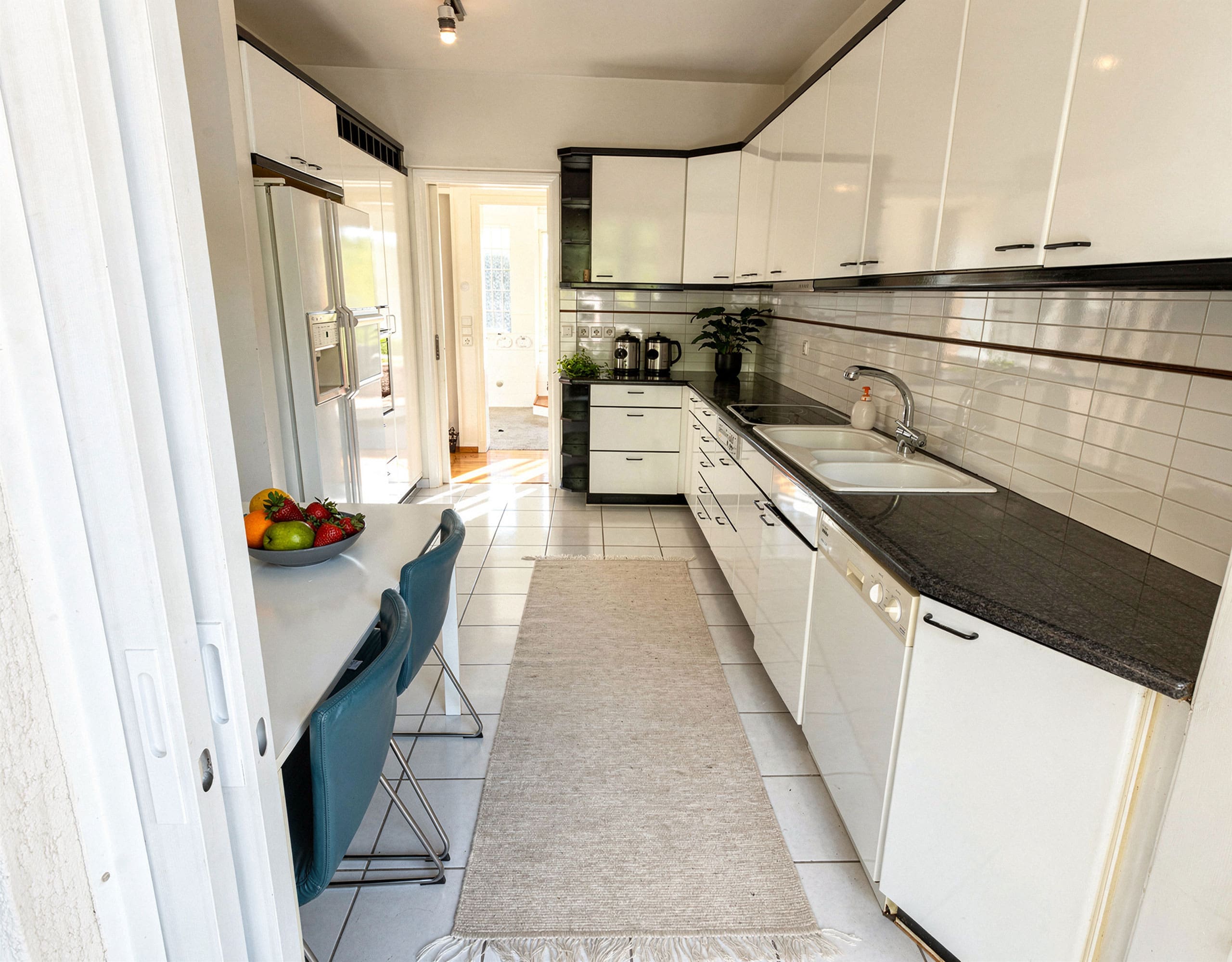 Voula Duplex 181 sqm – Galley Kitchen View Galley kitchen with white cabinets, black countertops, and long corridor layout, Voula, Athens Riviera, Greece