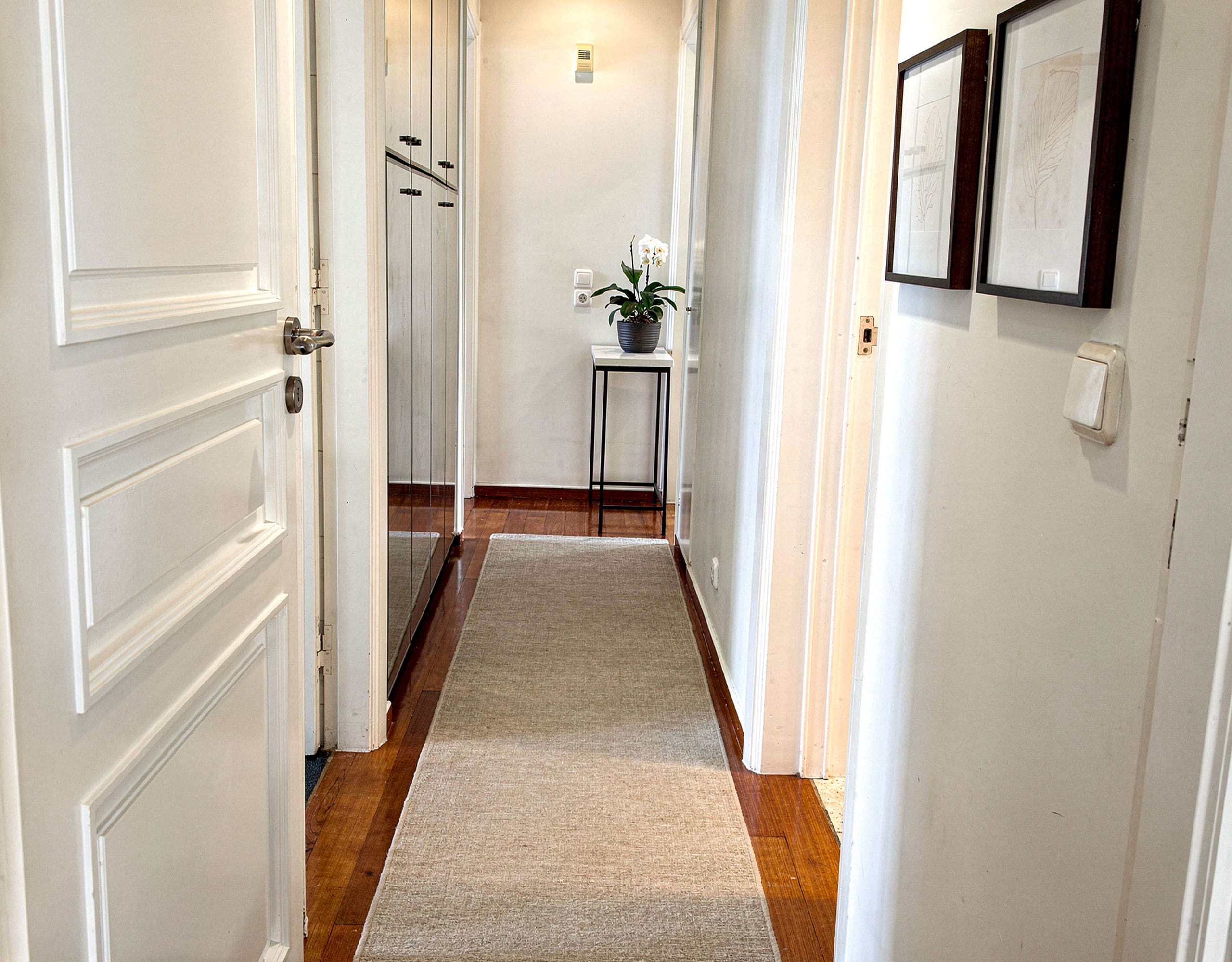 Voula Duplex 181 sqm – Interior Corridor Interior corridor with white walls, framed art, and wood flooring, Voula, Athens Riviera, Greece