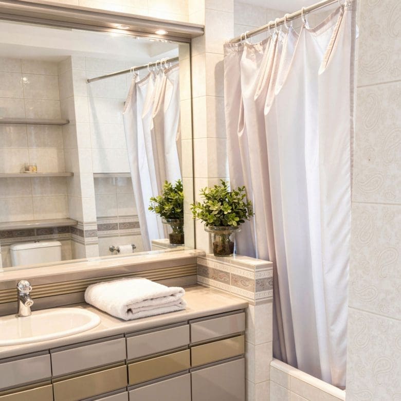 Bathroom with double sink vanity, large mirror, and bathtub with shower curtain, Voula, Athens Riviera, Greece