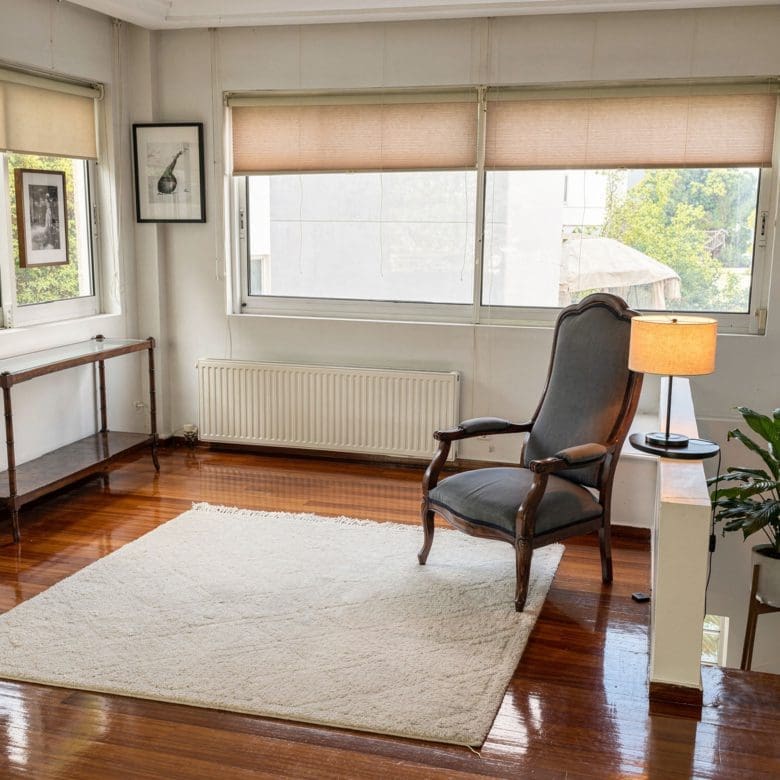 Bright living room with wood flooring, area rug, and desk by the window, Voula, Athens Riviera, Greece