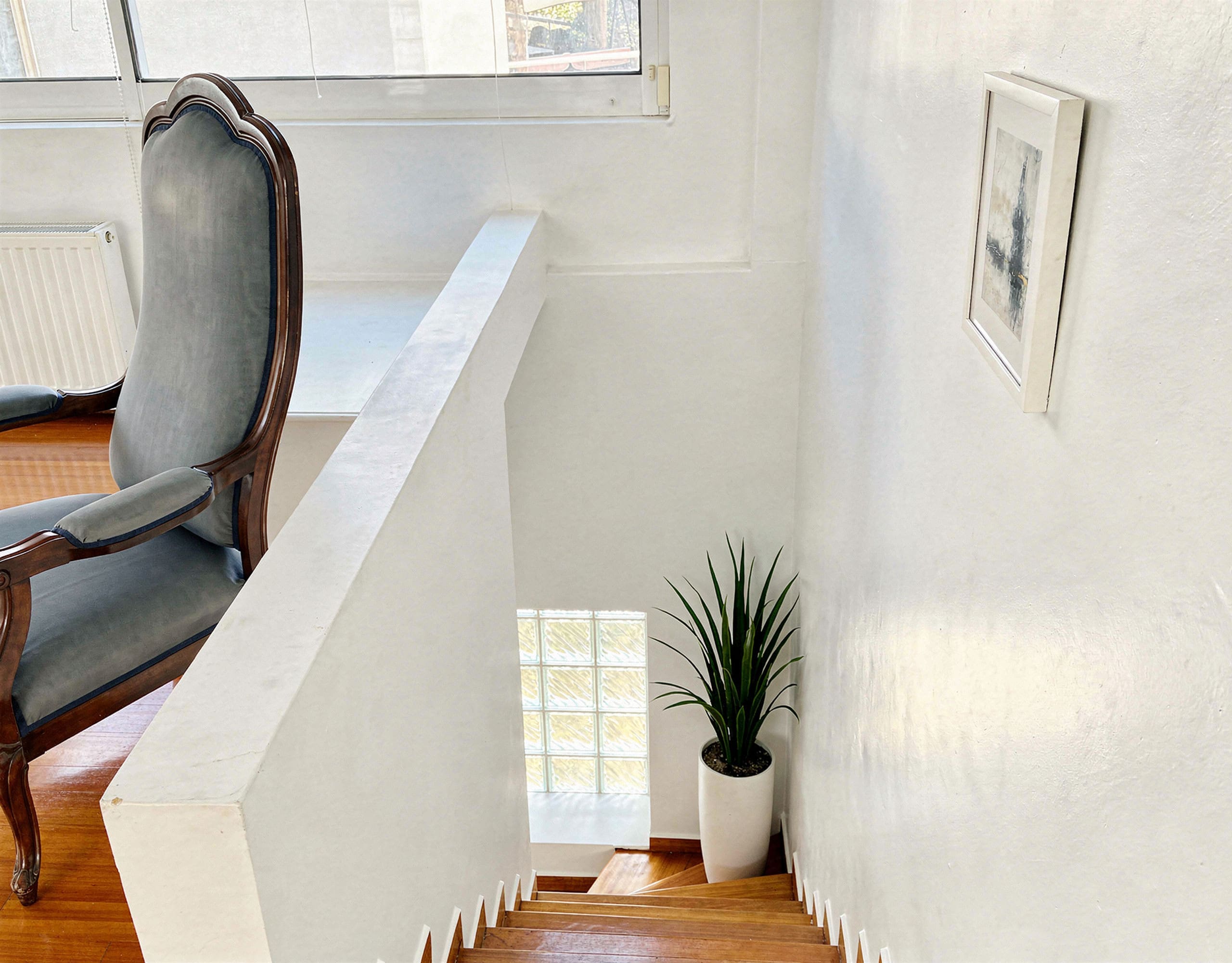 Voula Duplex 181 sqm – Upper Landing Upper landing with railing, wood flooring, and bright window, Voula, Athens Riviera, Greece