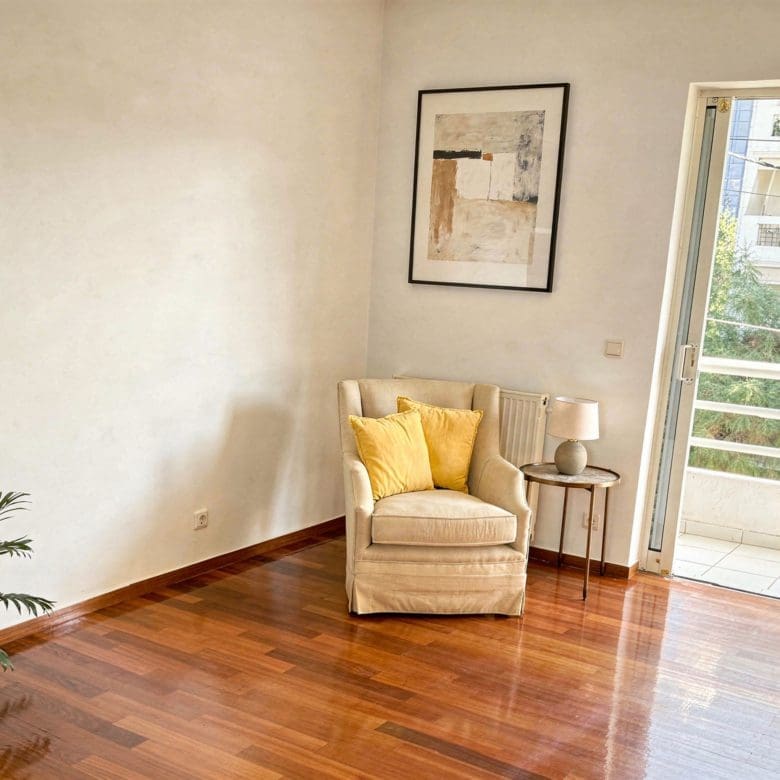Bright room with armchair, wood flooring, and balcony door, Voula, Athens Riviera, Greece