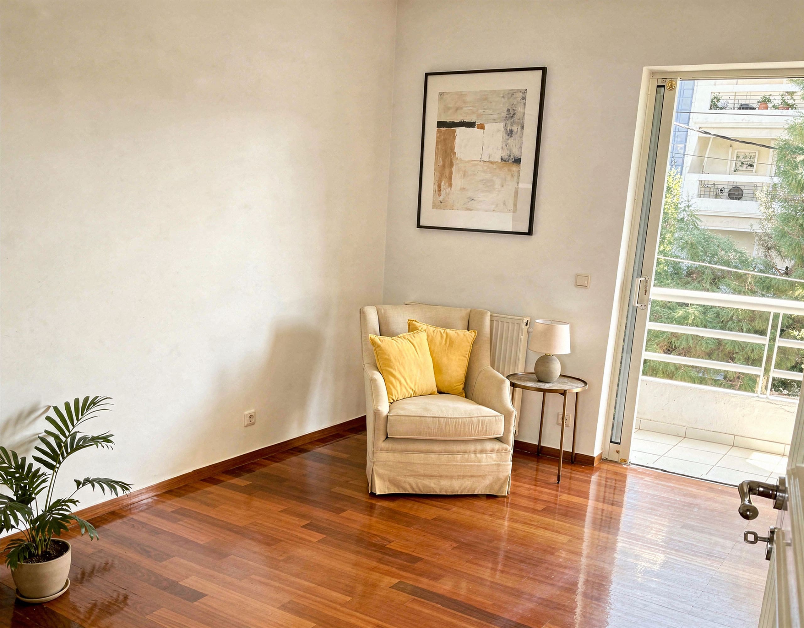 Voula Duplex 181 sqm – Bright Room With Balcony Access Bright room with armchair, wood flooring, and balcony door, Voula, Athens Riviera, Greece