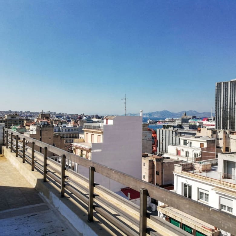 Rooftop view over the city with surrounding buildings and distant hills, Piraeus, Greece