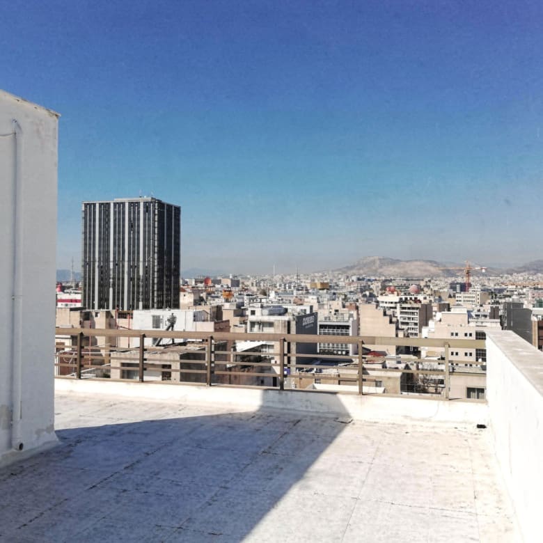 Rooftop terrace surface with open sky and city backdrop, Piraeus, Greece
