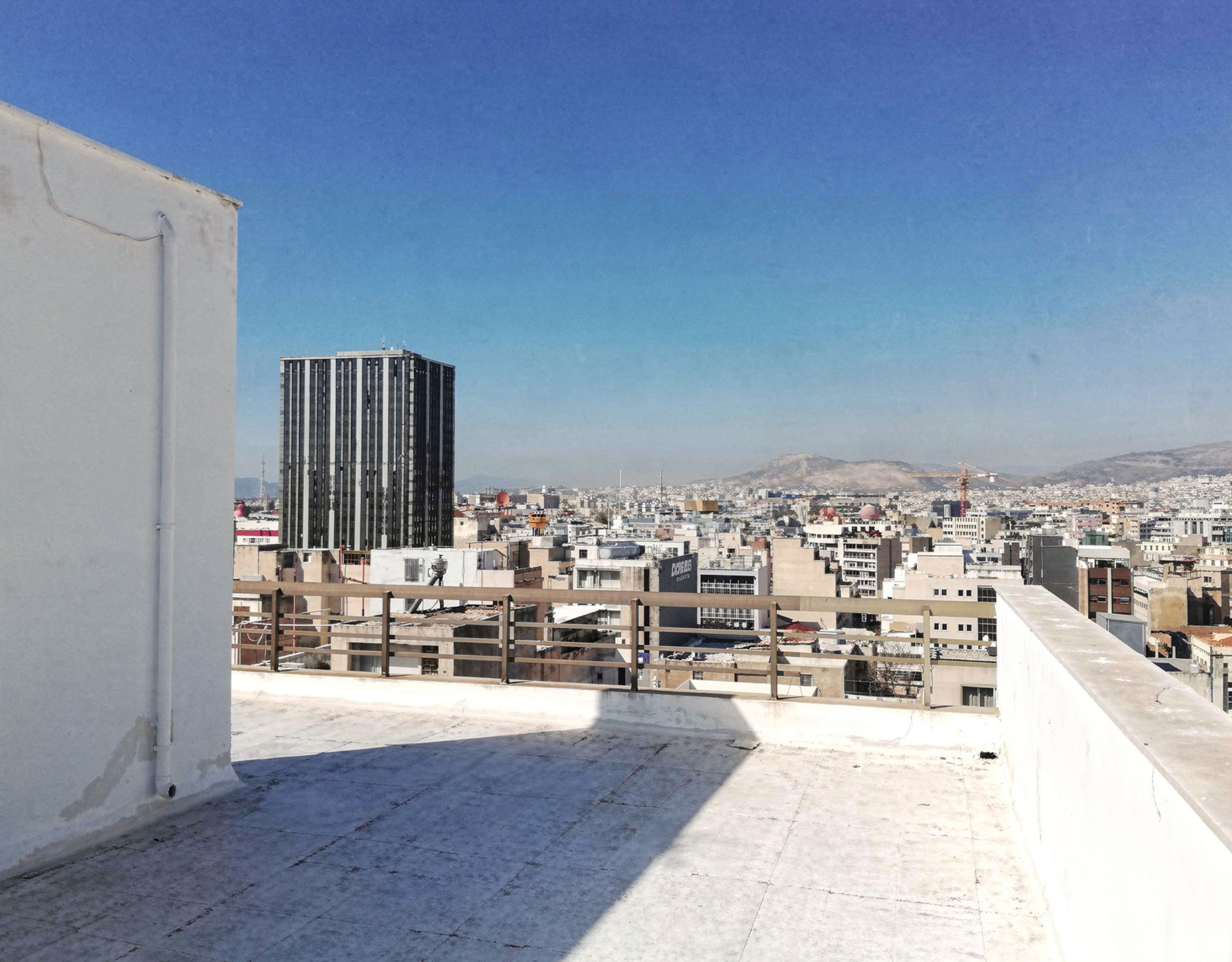 Rooftop terrace surface with open sky and city backdrop, Piraeus, Greece