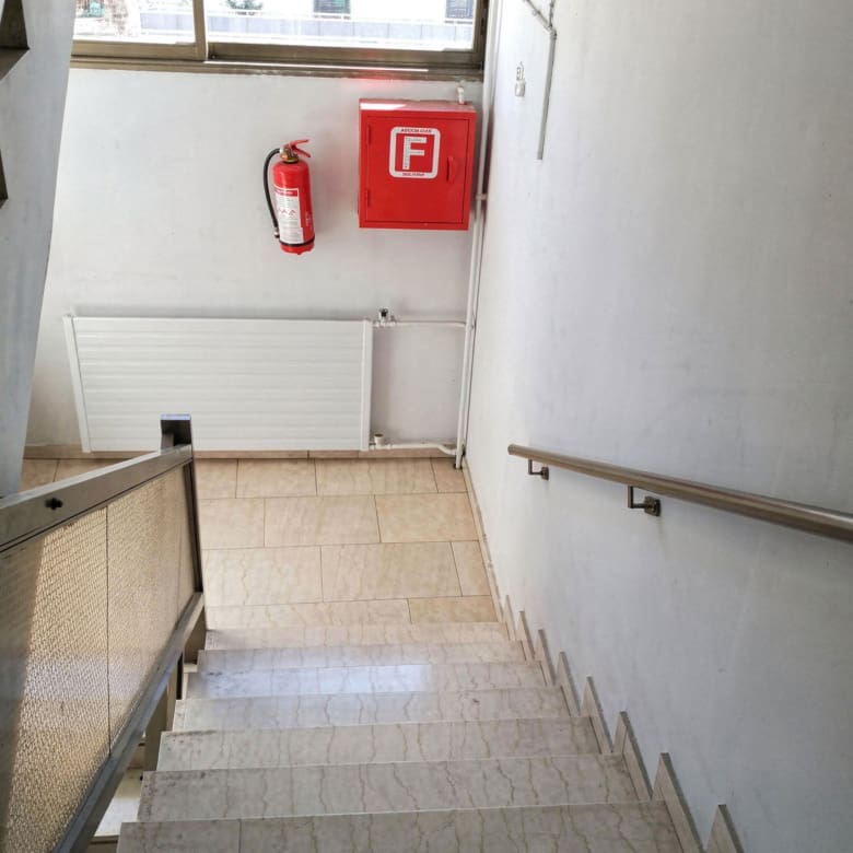 Stairwell with handrail and emergency equipment on the wall, Piraeus, Greece